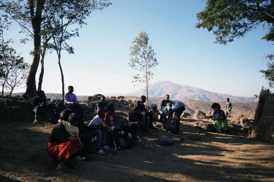 Young people and teenagers sitting and watching an elderly man being cared for