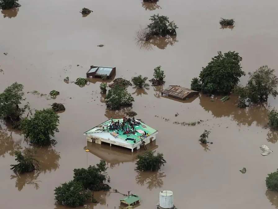 People take shelter on the roof of a house in an area completely flooded after Cyclone Idai passed through the city of Beira, Mozambique.