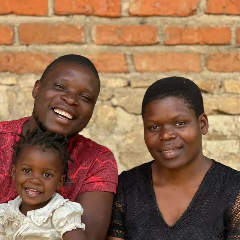 Banda e Caterin sorrindo, com uma criança pequena
